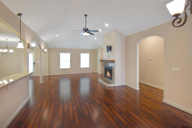 413 Maggie Cir, Flint, TX 75762 - unfurnished living room with arched walkways, wood finished floors, a warm lit fireplace, vaulted ceiling, and ceiling fan