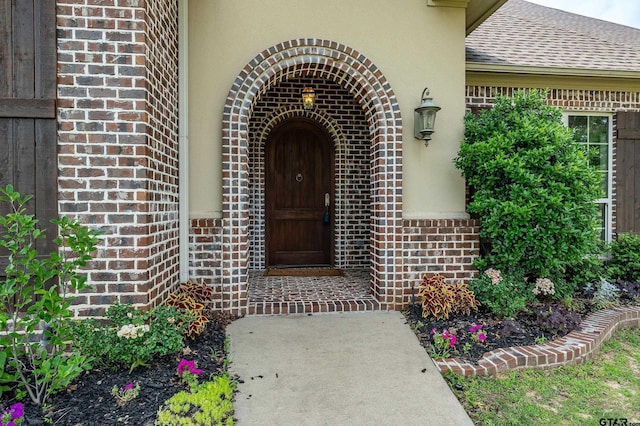 12105 Jazmin Cir, Flint, TX 75762 - view of exterior entry with brick siding, stucco siding, and a shingled roof