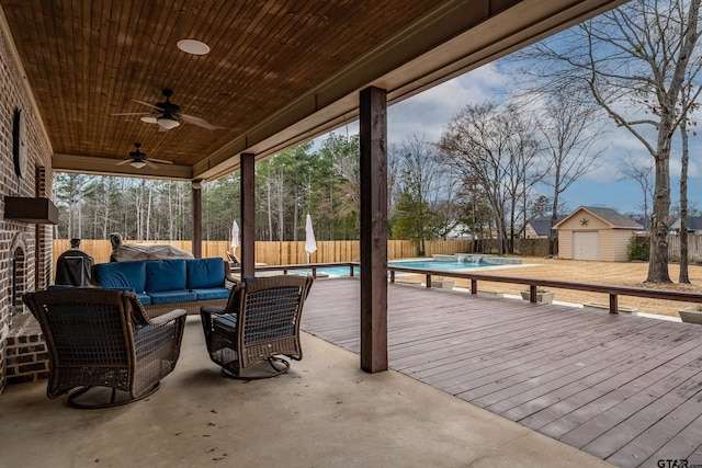 view of patio featuring a pool side deck, an outdoor hangout area, ceiling fan, and a storage unit