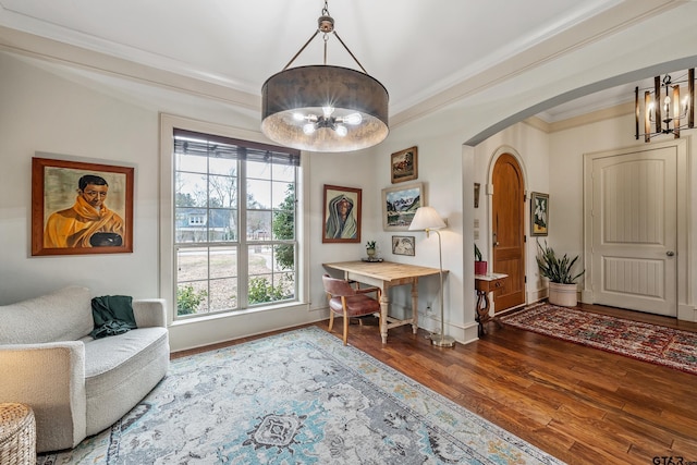 living area featuring crown molding, hardwood / wood-style flooring, and a chandelier