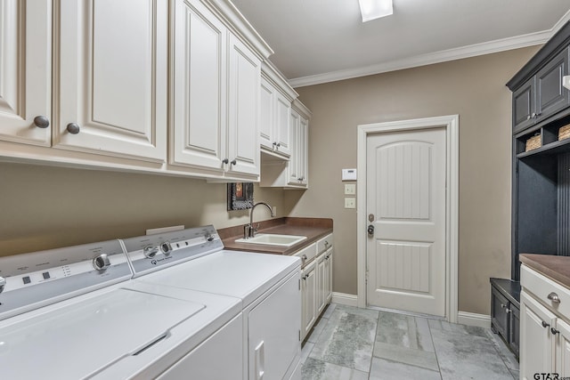 clothes washing area with cabinets, crown molding, sink, and washing machine and clothes dryer