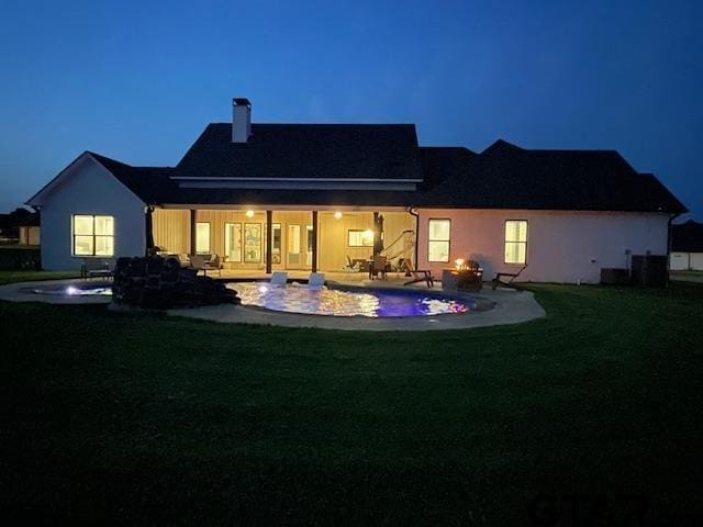 21830 County Mdws, Bullard, TX 75757 - back of house at night featuring an outdoor pool, stucco siding, a yard, and a patio