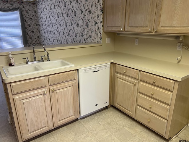 kitchen with white dishwasher, sink, and light brown cabinetry