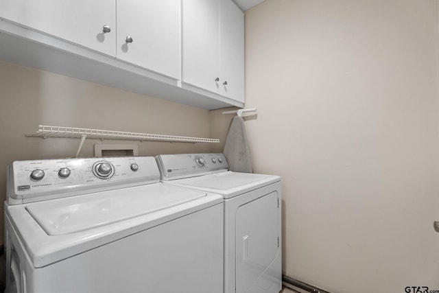 laundry area featuring washer and clothes dryer and cabinets