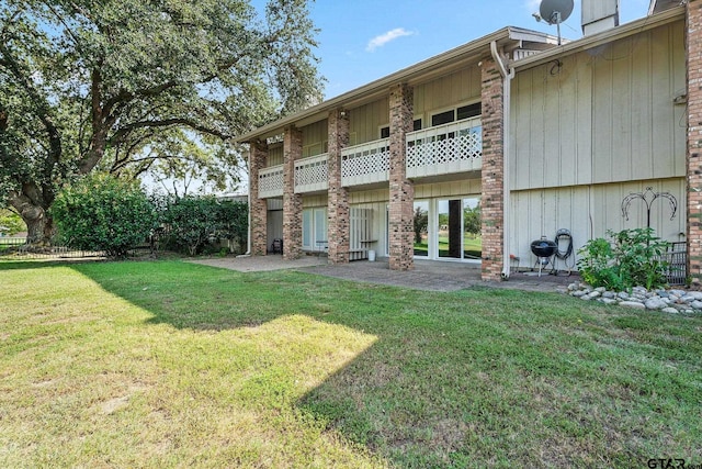 back of house with a yard and a balcony