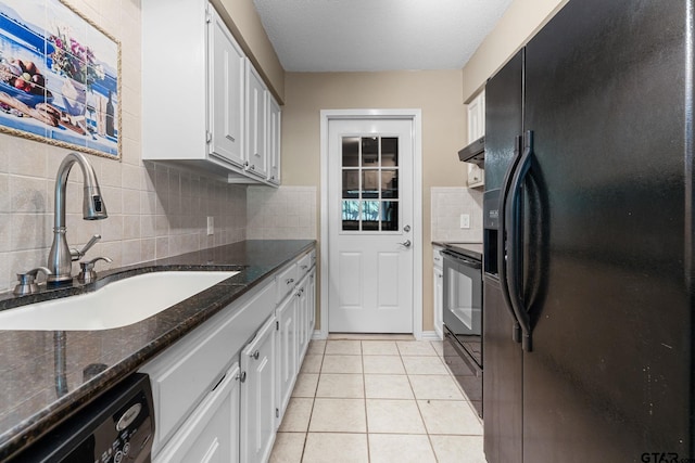 kitchen featuring black appliances, dark stone counters, range hood, sink, and white cabinets