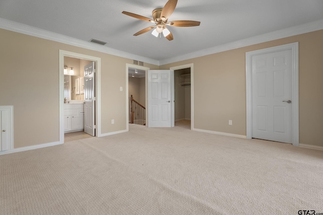 unfurnished bedroom featuring ensuite bathroom, light colored carpet, ceiling fan, and crown molding