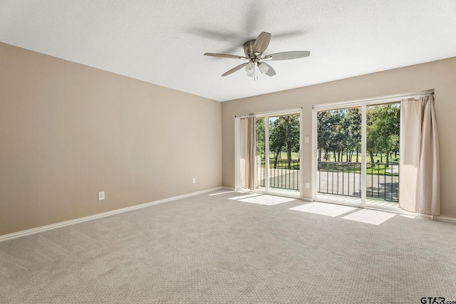 carpeted spare room with a textured ceiling and ceiling fan