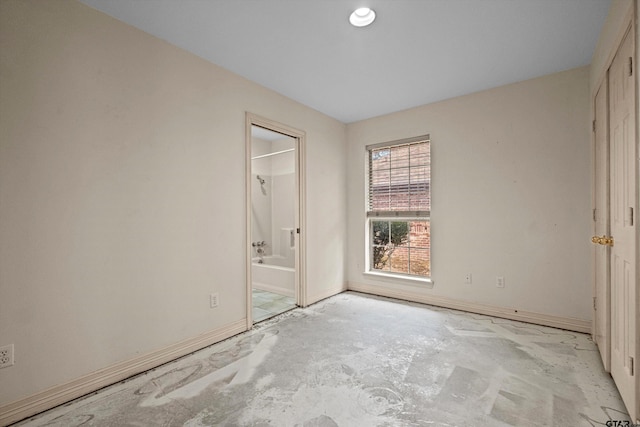 unfurnished bedroom featuring a closet and ensuite bath