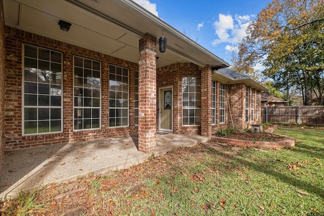 property entrance featuring a lawn and a patio