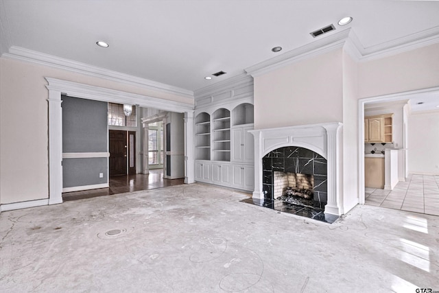 unfurnished living room featuring built in shelves, crown molding, and a premium fireplace