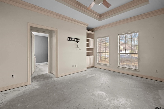 unfurnished room featuring ceiling fan, built in features, ornamental molding, and a tray ceiling