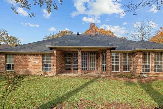 back of property featuring a lawn