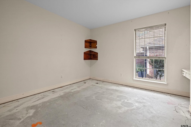 unfurnished room with concrete flooring