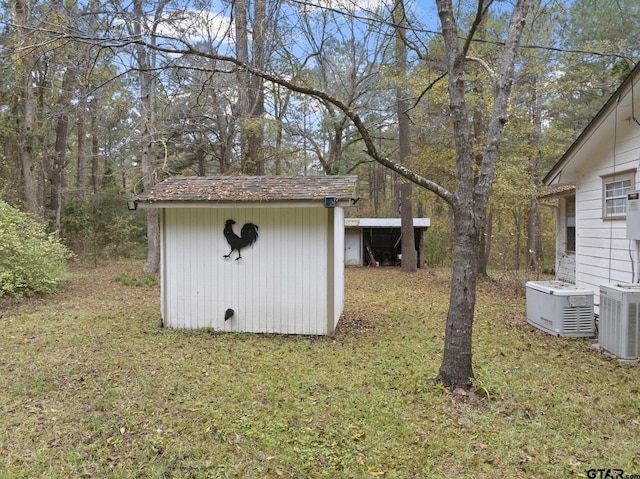 view of outdoor structure featuring cooling unit and a yard