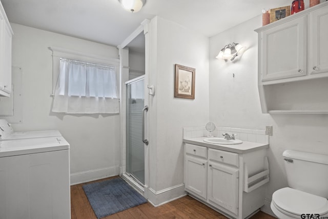 bathroom with vanity, hardwood / wood-style floors, washing machine and dryer, and walk in shower