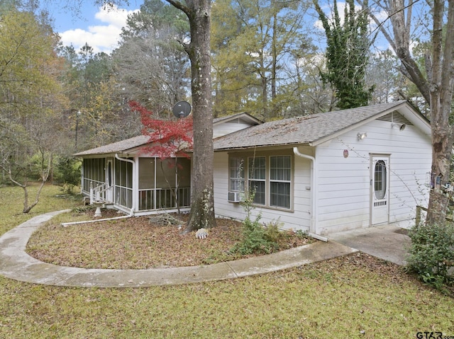 ranch-style house with cooling unit, a front yard, and a sunroom