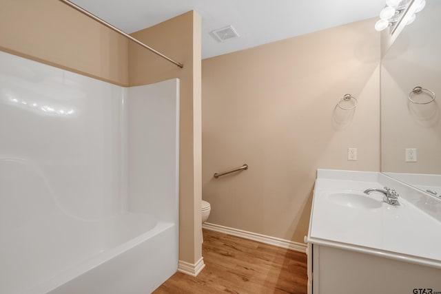 full bathroom featuring shower / bath combination, vanity, hardwood / wood-style floors, and toilet