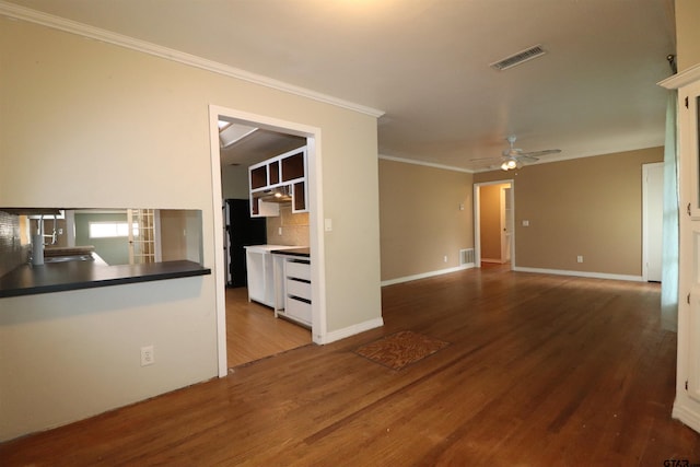 unfurnished living room with hardwood / wood-style floors, ornamental molding, sink, and ceiling fan