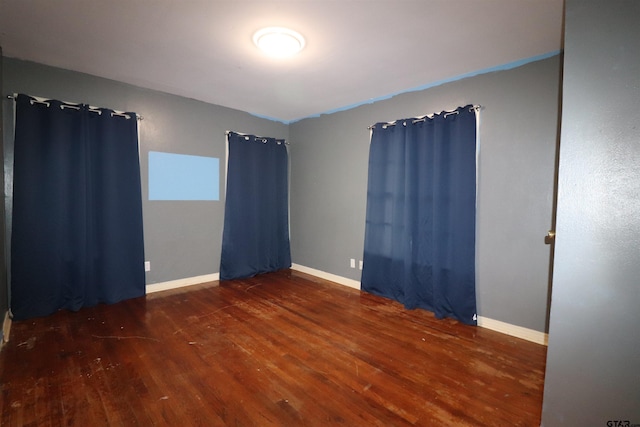 empty room with dark hardwood / wood-style flooring