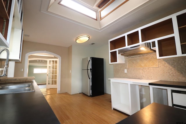 kitchen featuring sink, light hardwood / wood-style flooring, stainless steel refrigerator, tasteful backsplash, and french doors