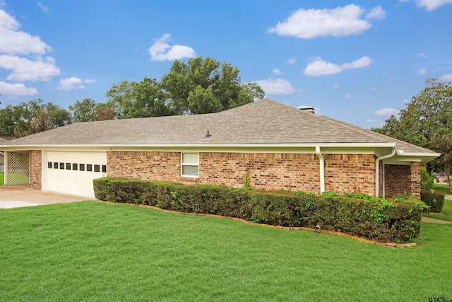 view of side of property with a lawn and a garage