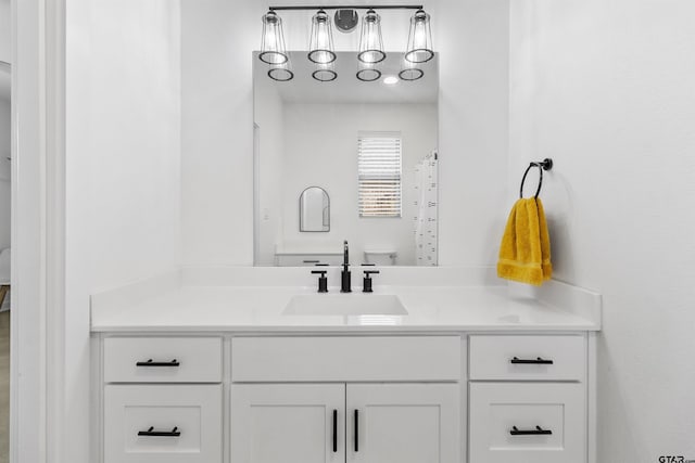 bathroom featuring a shower with shower curtain, vanity, and toilet