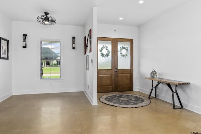 entrance foyer featuring concrete flooring and french doors