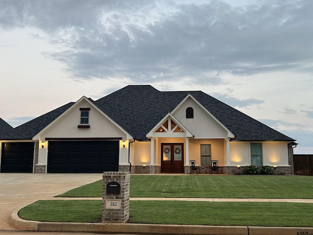 craftsman-style house featuring french doors, a front lawn, and a garage