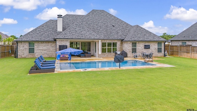 rear view of property with a yard, an outdoor living space, and a patio