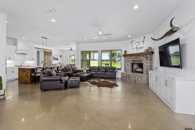 living room with ceiling fan, a fireplace, and concrete floors