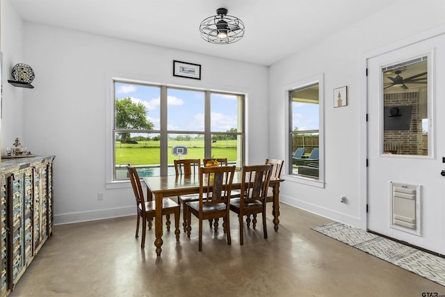 dining space with concrete floors and ceiling fan