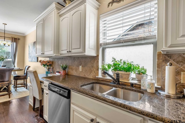 kitchen featuring pendant lighting, dark stone counters, sink, stainless steel dishwasher, and dark hardwood / wood-style floors