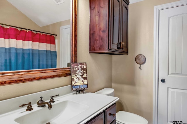 bathroom with a shower with curtain, vanity, toilet, and lofted ceiling