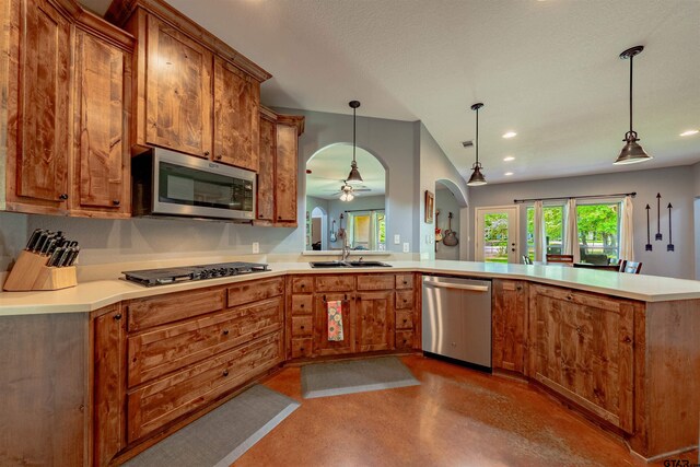 kitchen featuring kitchen peninsula, stainless steel appliances, ceiling fan, sink, and hanging light fixtures