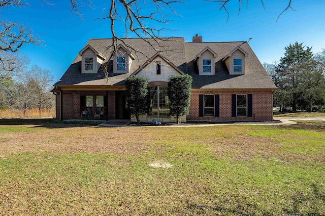 cape cod home featuring a front lawn