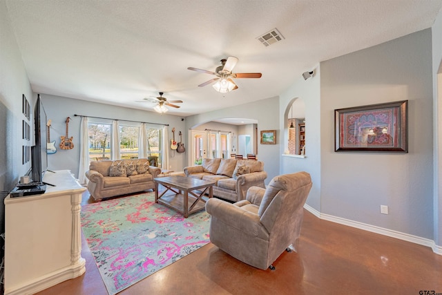 living room featuring a textured ceiling, concrete floors, and ceiling fan