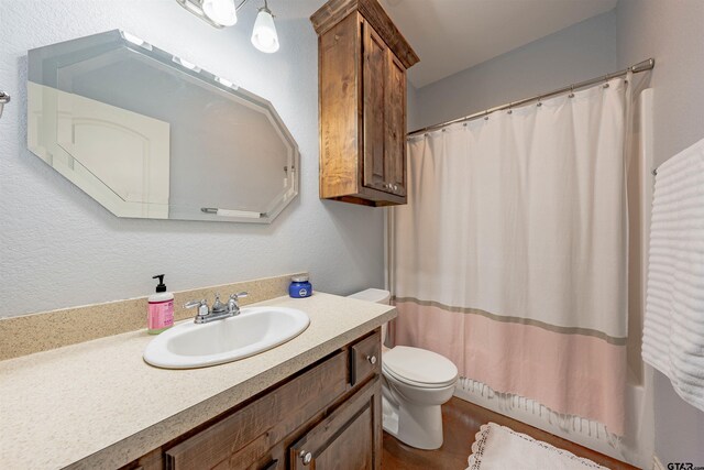 bathroom with vanity, curtained shower, and toilet