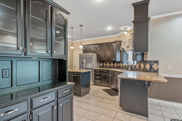 kitchen featuring crown molding, a kitchen island, backsplash, stainless steel fridge with ice dispenser, and light tile patterned floors