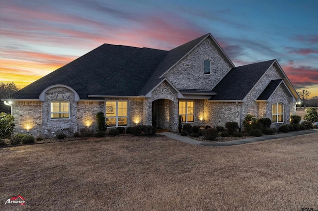 french country style house with a lawn