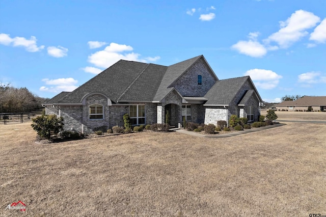 15631 Stallion Lake Blvd, Lindale, TX 75771 - french provincial home featuring a front yard, roof with shingles, brick siding, and fence