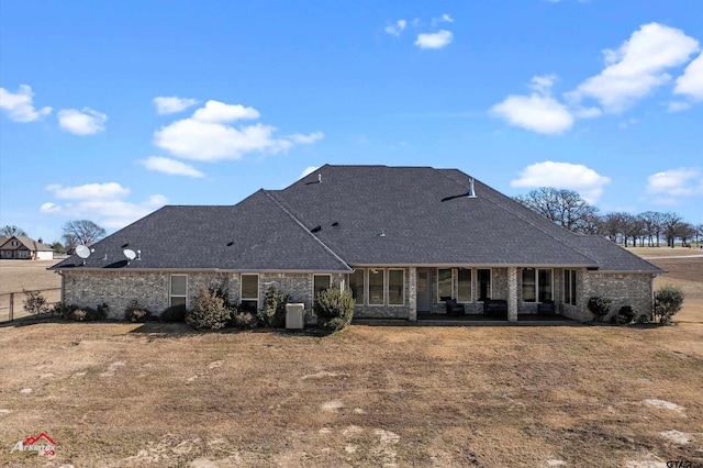 back of property featuring central AC and a yard