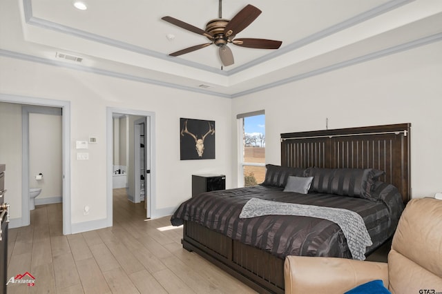 bedroom with crown molding, ceiling fan, a raised ceiling, and light wood-type flooring