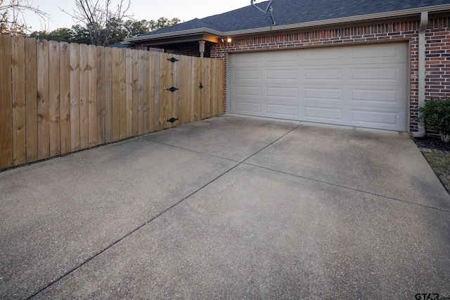 garage with driveway and fence