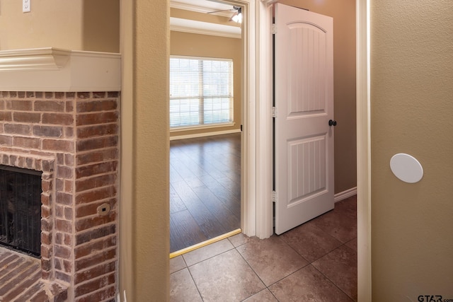 hallway with ornamental molding, tile patterned flooring, and baseboards