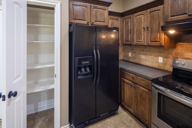 kitchen with dark countertops, black fridge with ice dispenser, backsplash, under cabinet range hood, and stainless steel electric range