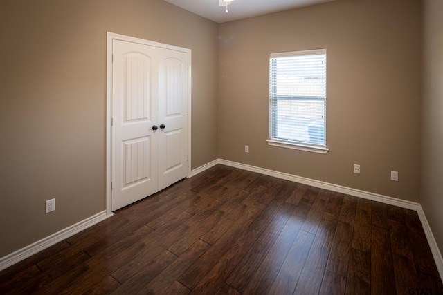 unfurnished bedroom featuring dark wood finished floors and baseboards