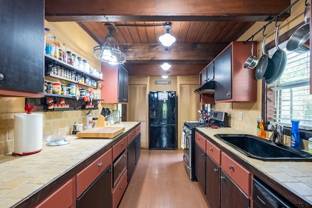 kitchen with wood ceiling, freestanding refrigerator, gas range, tile counters, and a sink
