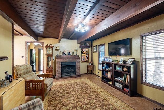 living room featuring beamed ceiling, wooden ceiling, a brick fireplace, tile patterned floors, and baseboards