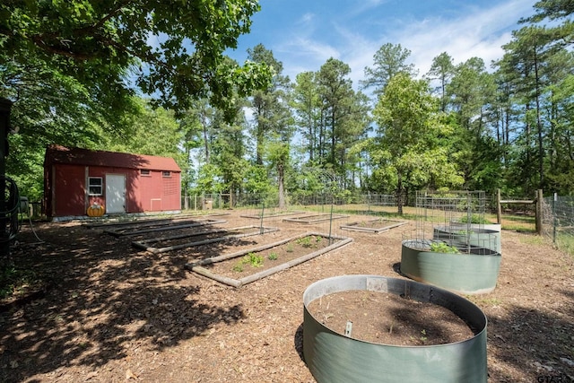 view of yard with fence, an outdoor structure, and a vegetable garden